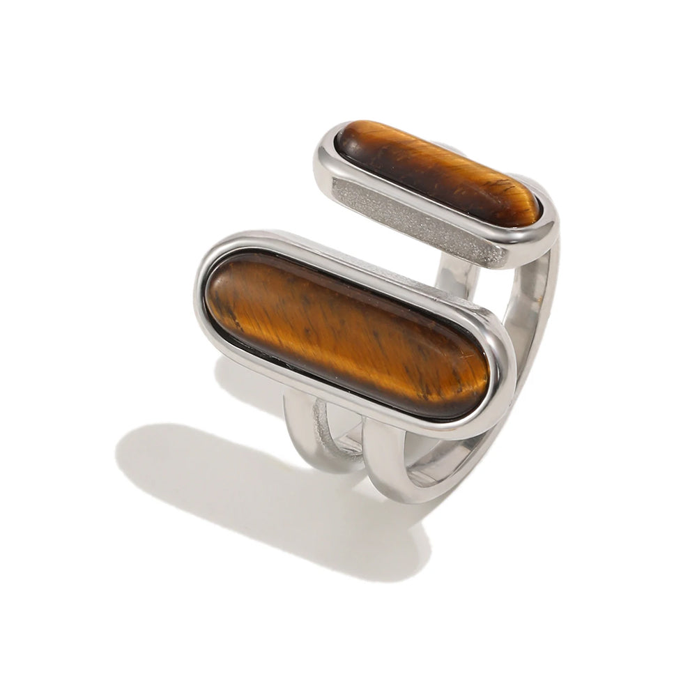 Dual tiger's eye open ring in silver, two staggered oval stones in bezel settings on open split band, white background
