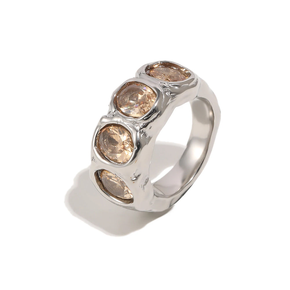 Silver hammered oval stone cocktail ring on white background, angled view showing four bezel-set champagne oval stones and rippled wide band, clean shadow
