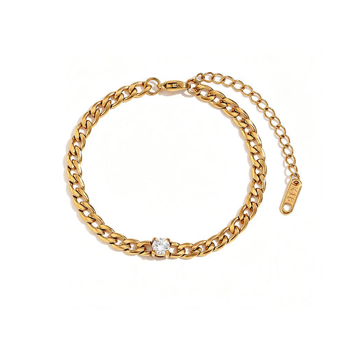 Gold Cuban link bracelet with round prong-set stone on white background, full bracelet circle shown with lobster clasp, extender chain and engraved tag, round stone centered in curb links, soft warm shadow
