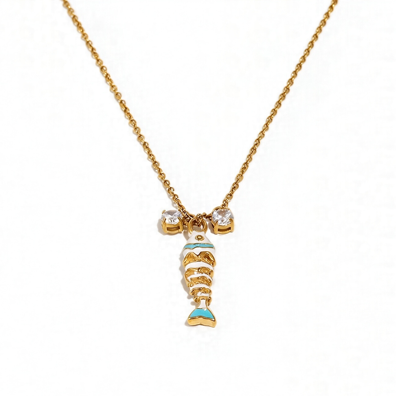 White enamel fish pendant necklace on gold cable chain, crystal accent detail, white background
