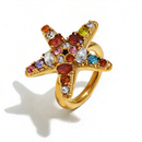Colorful crystal starfish ring in gold, close-up of multicolor prong-set stones, white background

