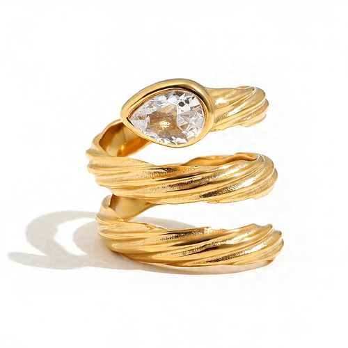 Spiral wrap ring in gold close-up, pear-cut crystal in smooth bezel at crown, rope-textured coiling band, white background
