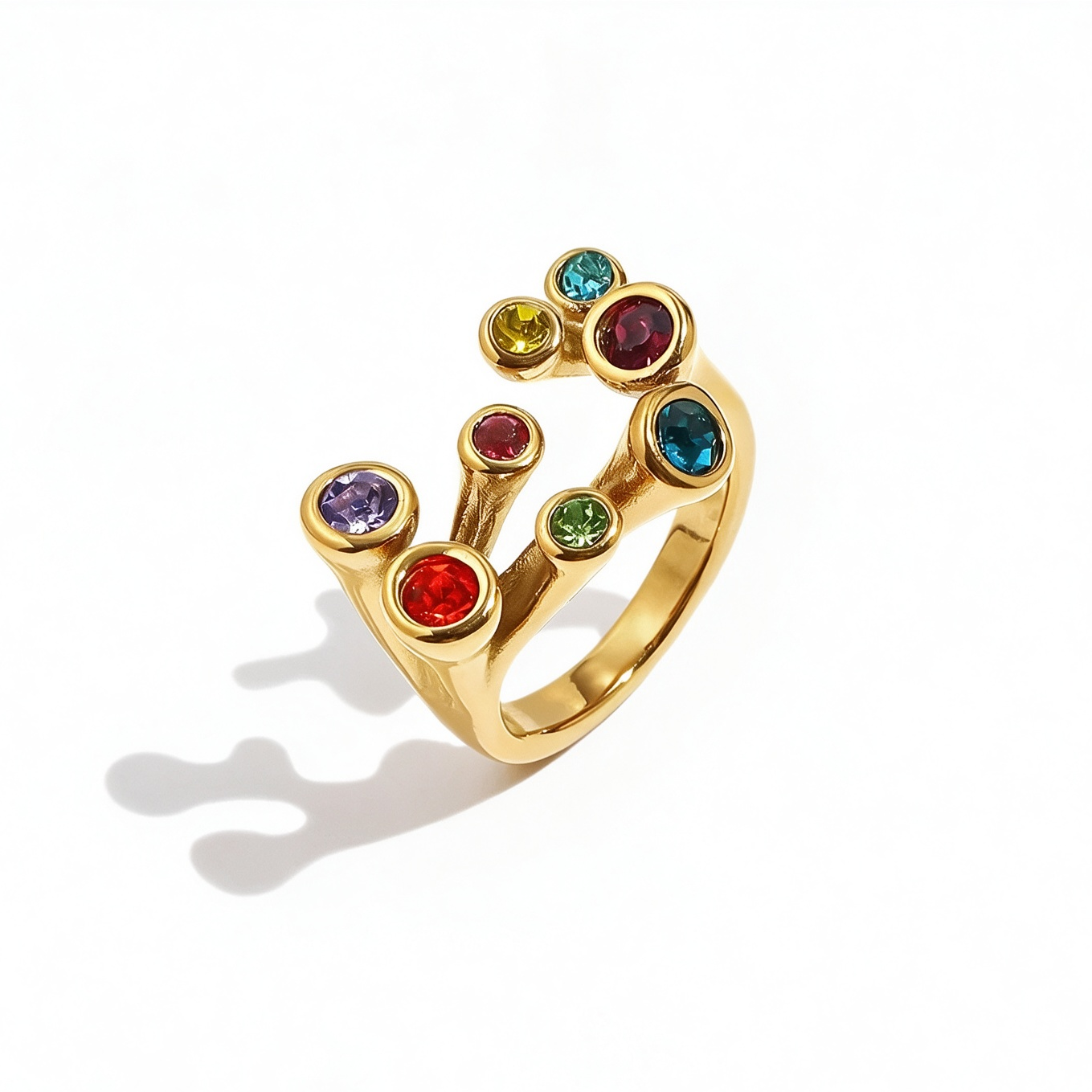 Gold multicolor stone scatter open band ring on white background, angled view showing nine bezel-set colored stones in scattered arrangement, open band gap visible, clean shadow
