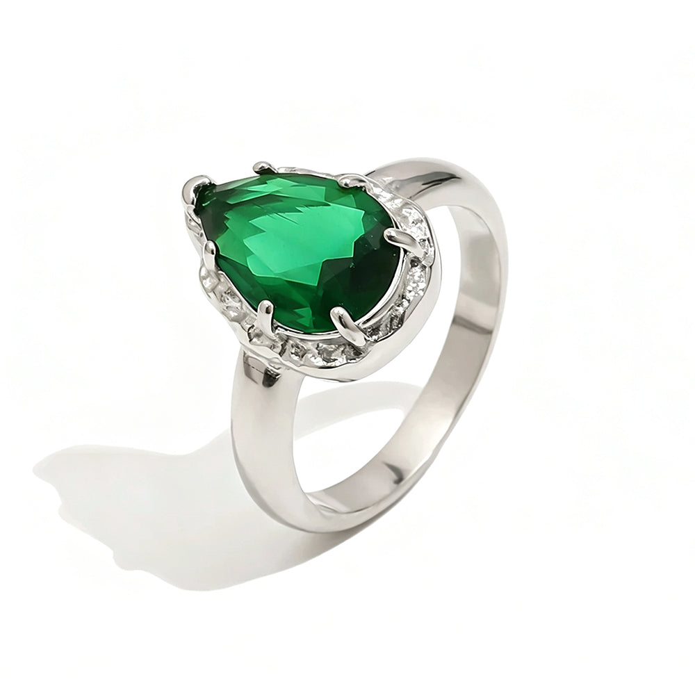 Silver green teardrop stone halo cocktail ring on white background, mint green faceted teardrop stone in multi-prong silver halo setting, tapered silver band, soft shadow
