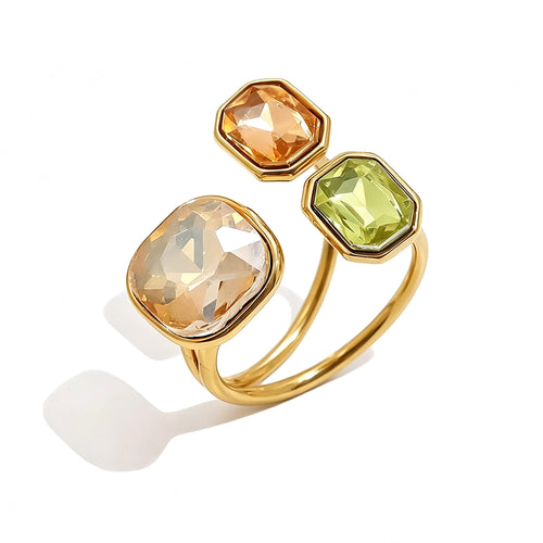Gold triple stone open cocktail ring in Sahara colorway on white background, large champagne cushion stone with amber and yellow-green octagon stones in graduated bezel settings, open band with warm shadow
