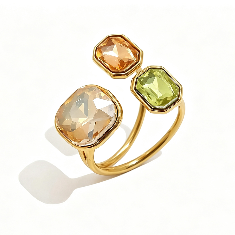 Gold triple stone open cocktail ring in Sahara colorway on white background, large translucent champagne cushion stone with amber and yellow-green octagon stones in graduated bezel settings, open band with warm shadow
