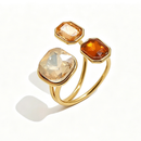 Gold triple stone open cocktail ring in Topaz colorway on white background, large translucent champagne cushion stone with light amber and deep cognac octagon stones in graduated bezel settings, open band
