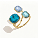 Gold triple stone open cocktail ring in Lagoon colorway on white background, large teal cushion stone with aqua blue and pale blue octagon stones in graduated bezel settings, open band with warm shadow
