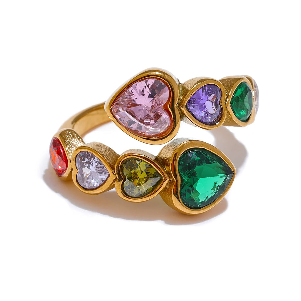 Gold multicolor heart stone open ring on white background, colorful heart-cut stones in alternating double-row arrangement showing pink, purple, green, red and olive stones in gold bezel settings, open adjustable band
