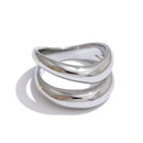 Silver double wave band ring on white background, two-band wave structure with upper band arching above lower band, mirror-polished silver surface, cool light with long directional shadow
