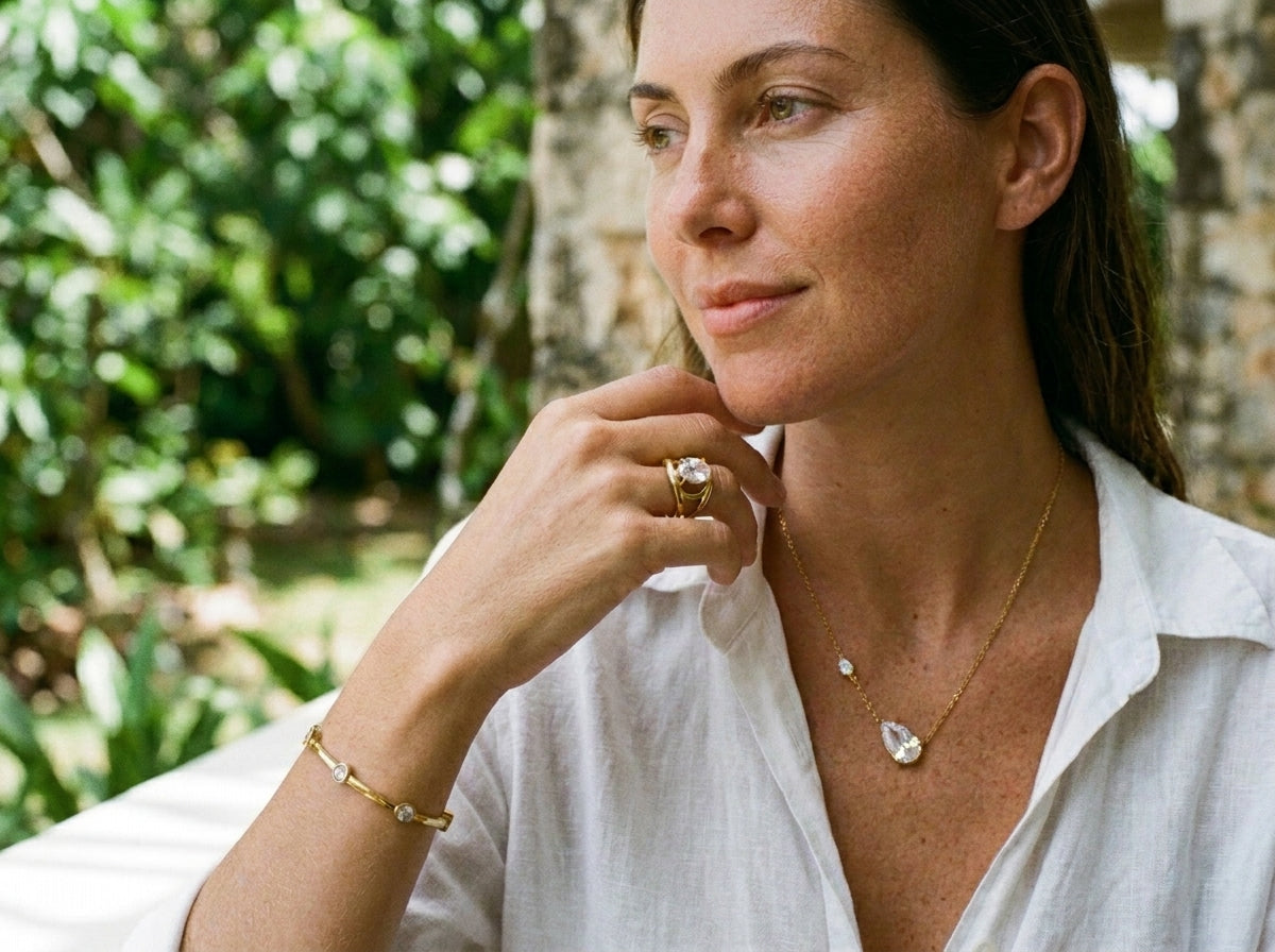 Woman wearing gold ring, bracelet and necklace set in natural light — SEIYI jewelry collection