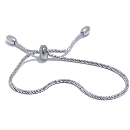 Silver snake chain slider bracelet on white background, S-curve layout showing barrel slider at center with two snake chain ends tipped with polished ovals, cool light with soft shadow
