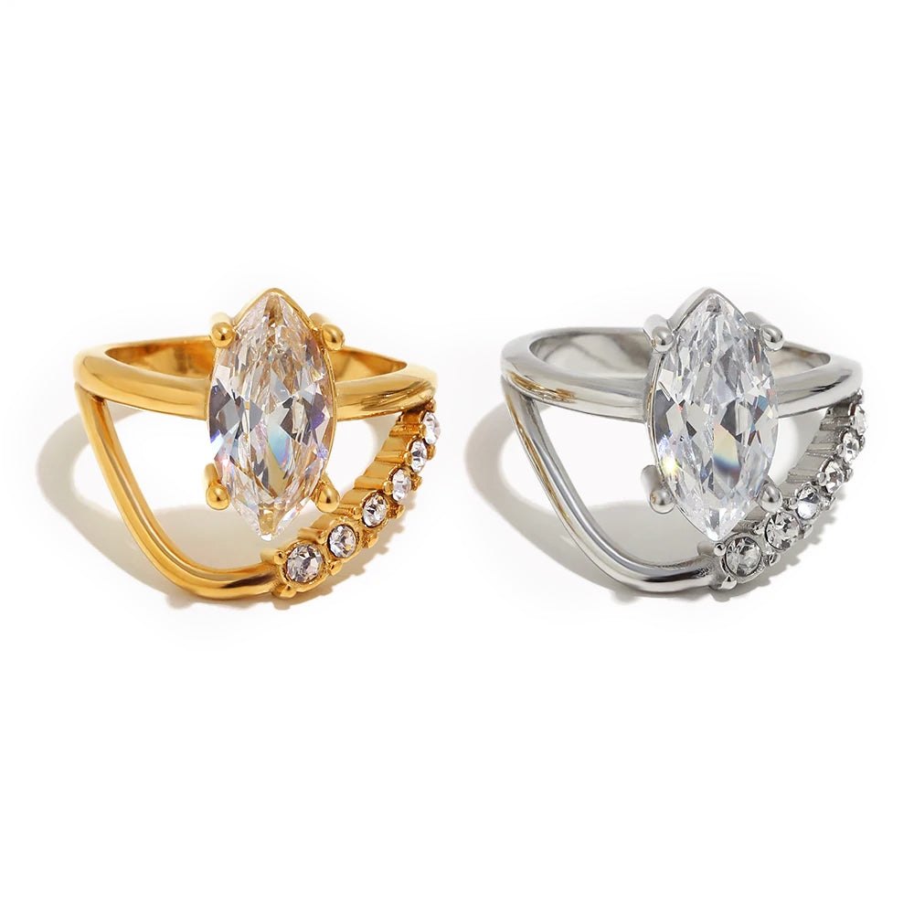 Marquise crystal double band ring in gold and silver, oversized center stone in four-prong setting, white background
