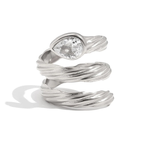 Spiral wrap ring in silver close-up, pear-cut crystal in smooth bezel at crown, rope-textured coiling band, white background
