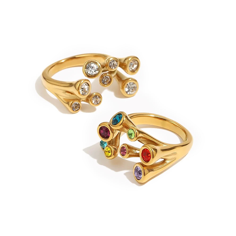 Gold multicolor stone scatter open band ring and clear stone version side by side on white background, nine bezel-set stones in scattered arrangement, open band visible
