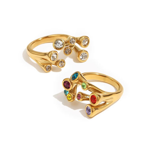 Gold multicolor stone scatter open band ring and clear stone version side by side on white background, nine bezel-set stones in scattered arrangement, open band visible
