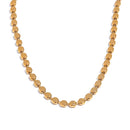Gold disc chain necklace on white background, continuous flat disc links in U-shape, mirror-polished round discs with thin edges visible, warm white background with soft shadow beneath
