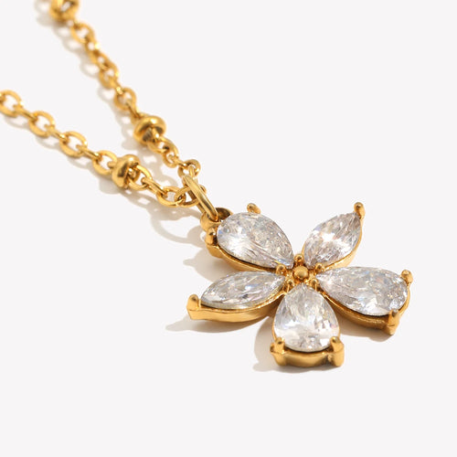 Close-up of crystal flower pendant necklace, marquise CZ petals in gold prong setting, detail shot
