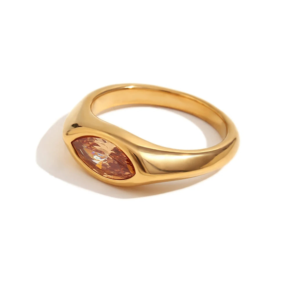 Gold marquise stone dome signet ring in brown colorway on white background, warm amber marquise-cut stone in mirror-polished dome band, side angle showing dome profile and band shoulder curve, long warm shadow
