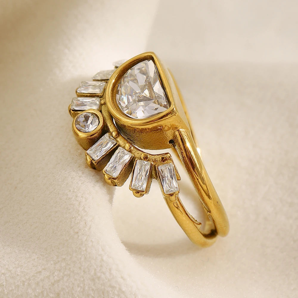 Gold half moon fan stacked ring on cream fabric surface, three-quarter side angle showing half-moon bezel depth, baguette fan stone arrangement and split double band gap, soft diffused light
