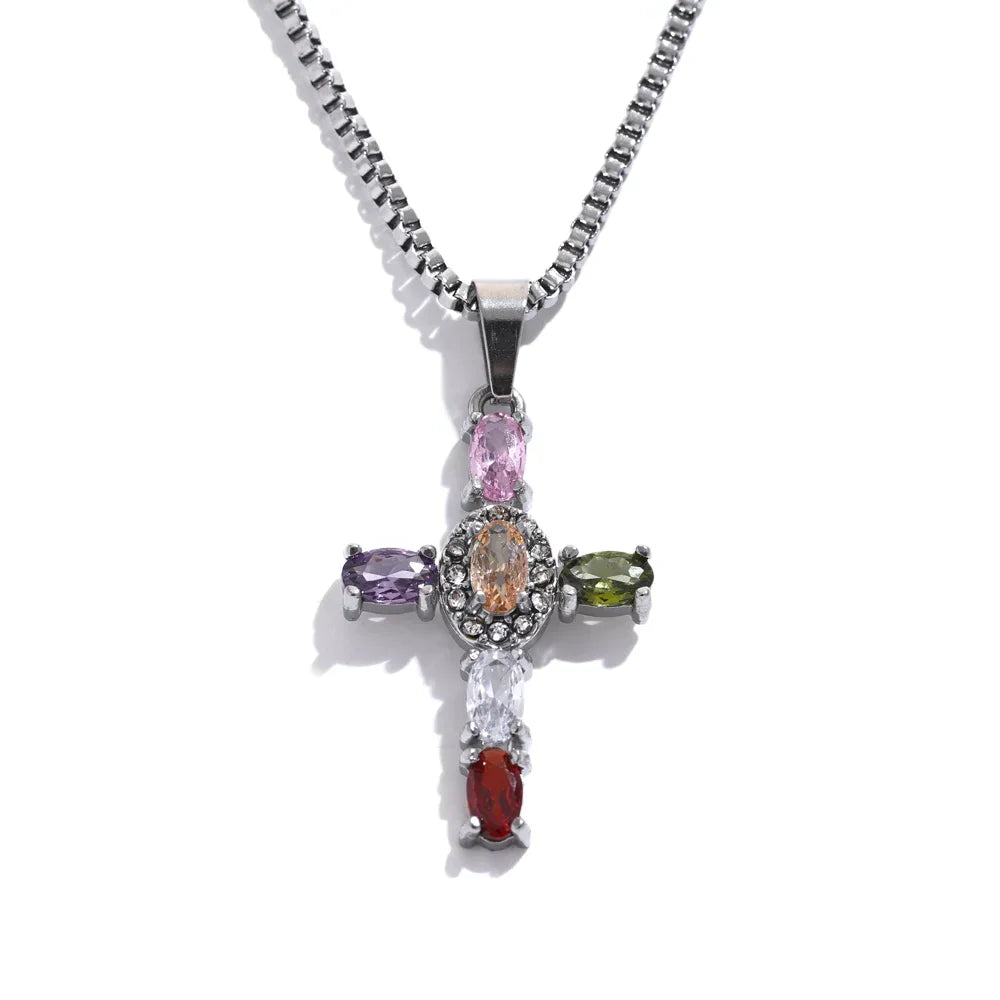 Silver multicolor stone cross pendant necklace on white background, full necklace view showing silver box chain and cross pendant with pink, orange, purple, olive, clear and red oval stones, cool directional light
