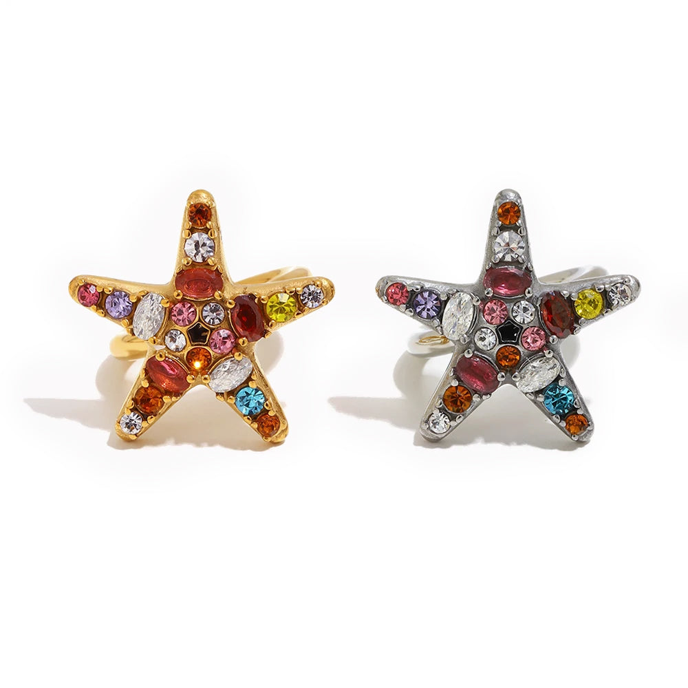 Colorful crystal starfish ring in gold and silver, multicolor prong-set stones on starfish face, white background
