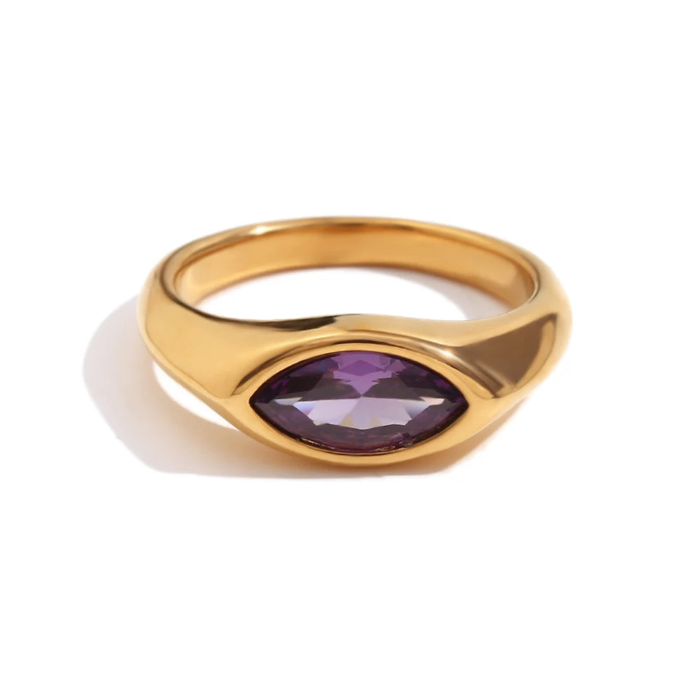 Gold marquise stone dome signet ring in purple colorway on white background, deep violet marquise-cut stone bezel-set in wide mirror-polished gold dome band, long warm directional shadow
