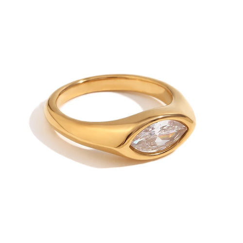 Gold marquise stone dome signet ring in white colorway on white background, clear crystal marquise-cut stone bezel-set in mirror-polished gold dome band, soft warm shadow
