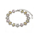 Silver multicolor square stone tennis bracelet on white background, mixed pastel square stones in star-prong settings, full bracelet with lobster clasp and extender chain, cool light with soft shadow
